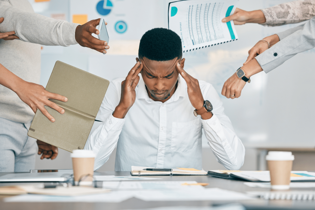 man sitting at his desk dealing with Anxiety Disorder in the Workplace||woman sitting in a chair struggling with Anxiety Disorder in the Workplace
