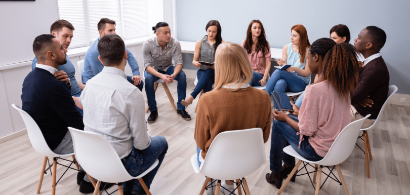patients sitting in group discussing what is php therapy vs iop|man discussing with his therapist what is php therapy vs iop|woman embracing another woman after choosing between what is php therapy vs iop