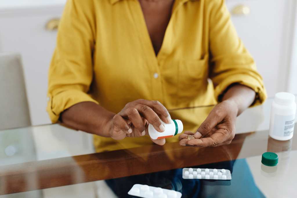 woman sitting at a table taking her medication while wondering what are brain zaps|woman speaking with her therapist about what are brain zaps|woman struggling with what are brain zaps