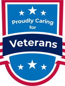 red, white, and blue shield reading "Proudly Caring for Veterans"