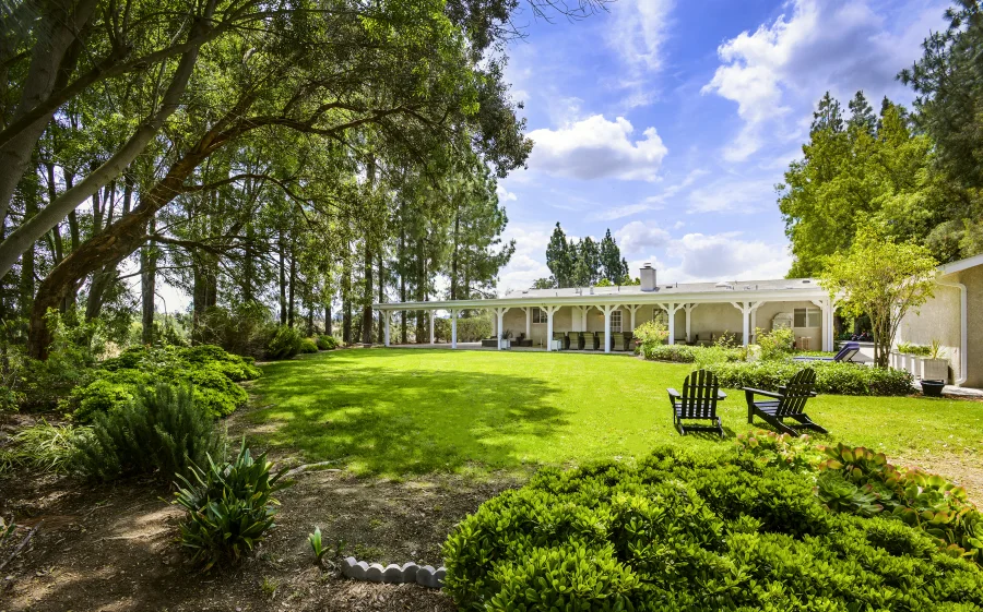 Wide lawn and mature trees surrounding The Meadowglade residential cottage