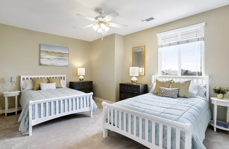 Two beds in a bright main-house bedroom, part of optional supportive housing