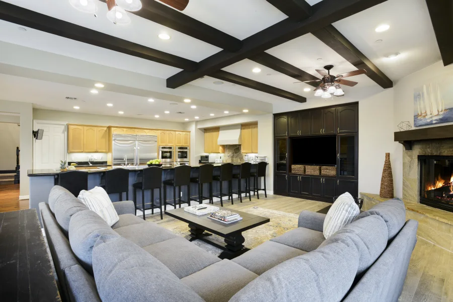 Fireside lounge with a sectional sofa and open kitchen in The Meadowglade main house, part of optional supportive housing