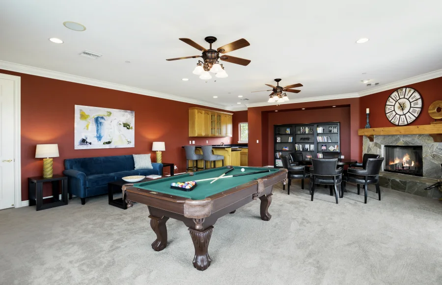 Billiard table, seating and fireplace in the main-house games lounge, part of optional supportive housing